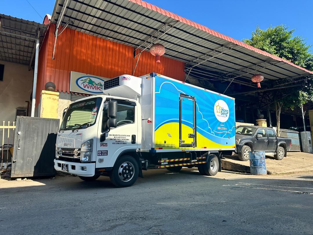 Isuzu truck with a blue and yellow refrigerated body at the WMK workshop
